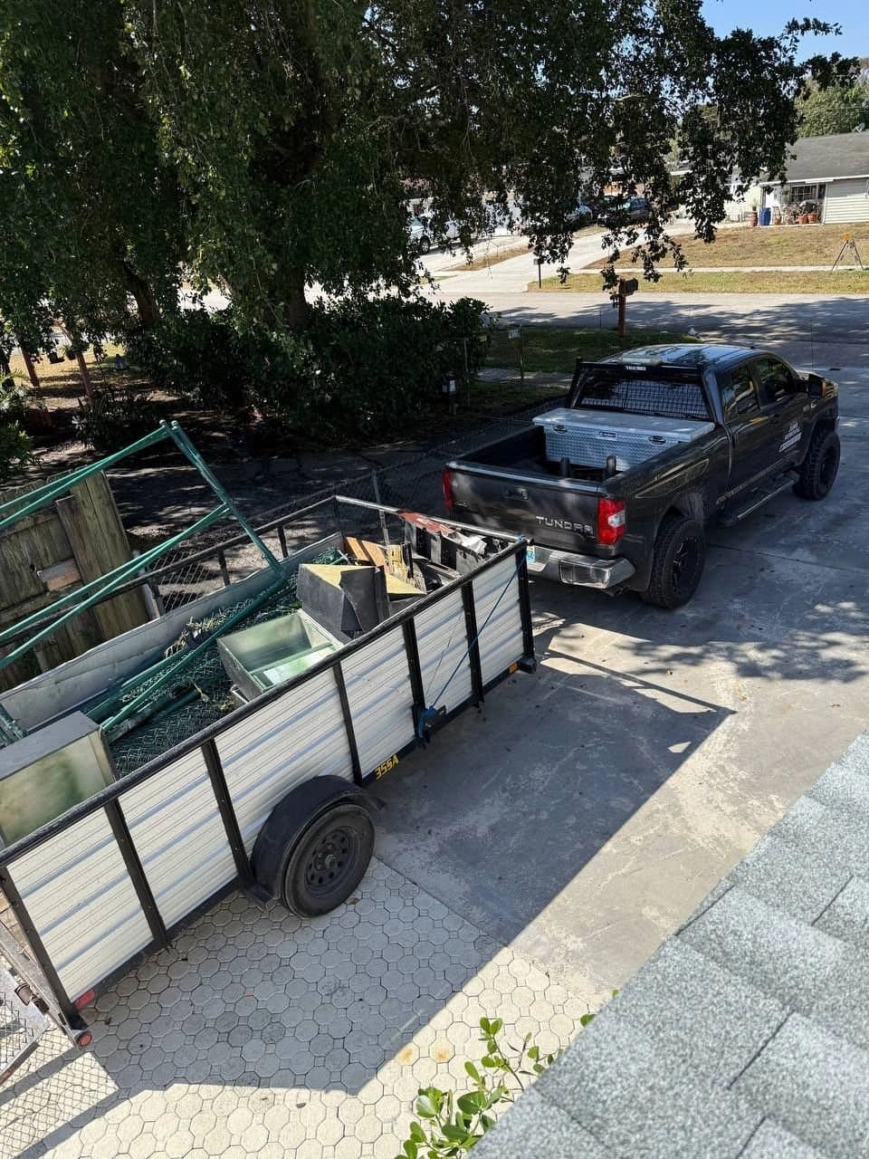 Overhead view of the JunkHustle truck and trailer loaded with metal debris in a driveway